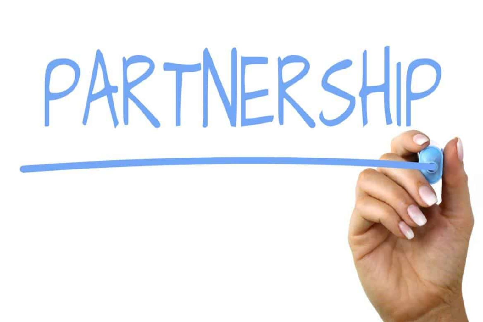 Hand writing the word “PARTNERSHIP” in blue marker with an underline, symbolizing collaboration